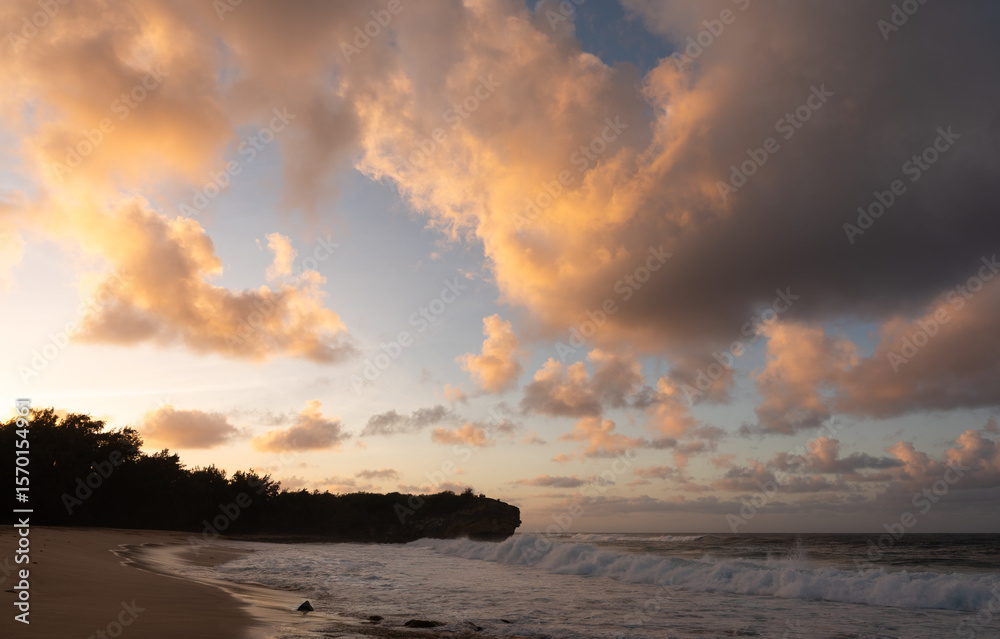 Obraz premium Beautiful sunrise and vibrant clouds above Shipwreck beach on Kauai