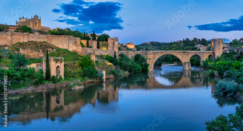 San martin bridge reflecting in tagus river at blue hour, toledo, spain