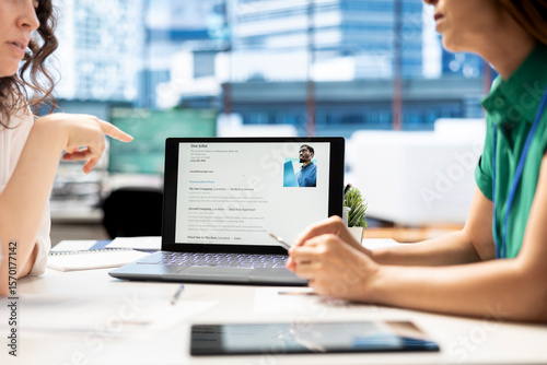 Photos HR manager looking at CVs on tablet to vet selected applicants and ensure their skills match role needs