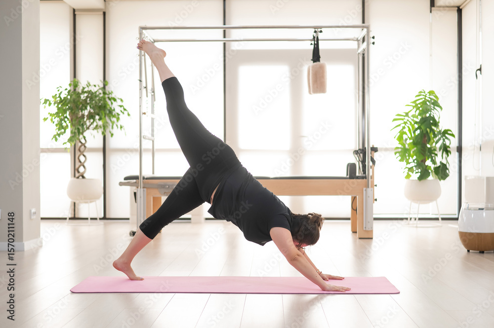 Obraz premium A plump woman does Pilates in a studio. 