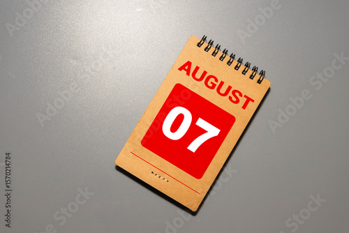 Cube shape calendar for August 07 on wooden surface