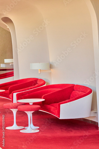 Red Mid-Century Armchairs and White Railings in Atrium
