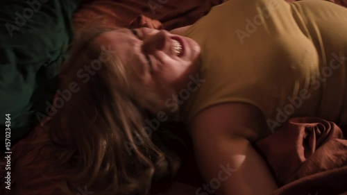 Possessed young woman writhing on bed during exorcism