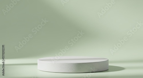 Minimalist white pedestal with soft shadows on a pale green background
