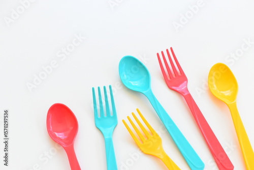 colorful spoon and fork isolated on white background, plastic cutlery for picnic