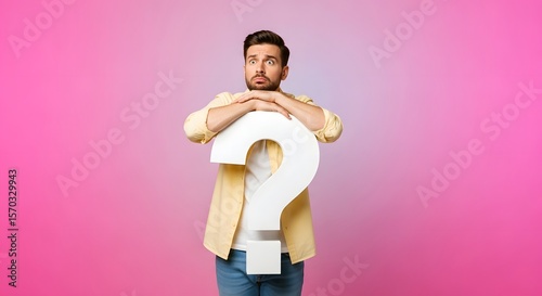 Worried Man Holding Large White Question Mark on Pink Background