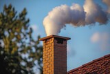 Smoke emerging from brick chimney against clear blue sky in bright sunlight is coming out