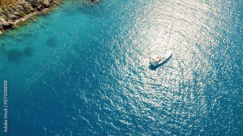 Sailboat floating in sparkling blue sea water off the coast of Kefalonia, Greece
