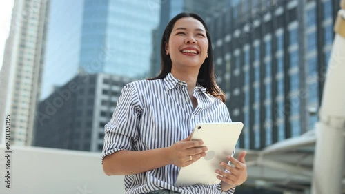 slow motion manager businesswoman hold laptop and looking away through while stand outside office building tower for better vision and thinking about new business project for startup