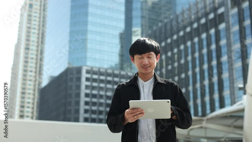 slow motion investor or businessman hold digital tablet while standing outside building in the city and looking away with vision for future financial and motivation on business achievement concept