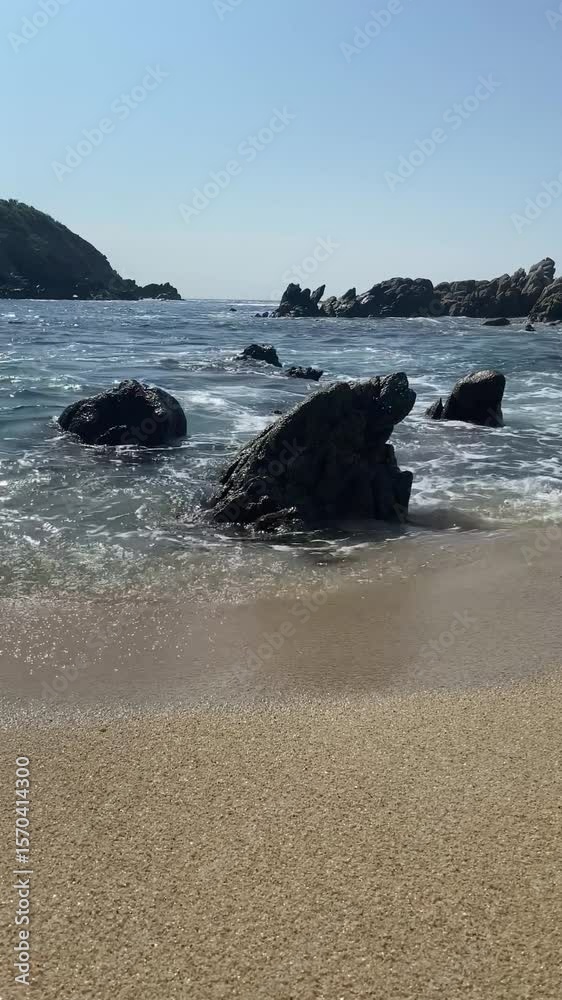 Toma a contra-luz de olas chocando en la orilla del mar en un atardecer.