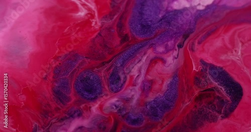 Shimmer fluid. Ink particles. Defocused purple red crimson colorful water glitter acrylic liquid flowing on abstract art background.