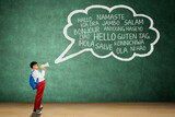 Asian Schoolboy Speaking Through Megaphone with Multilingual Hello Words on Chalkboard