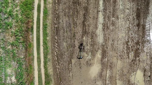 Drone footage farmers is using a small walking tractor to plow the soil 