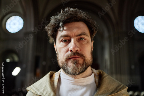 Fotografija Portrait of middle aged Caucasian man wearing clerical robe standing in church l