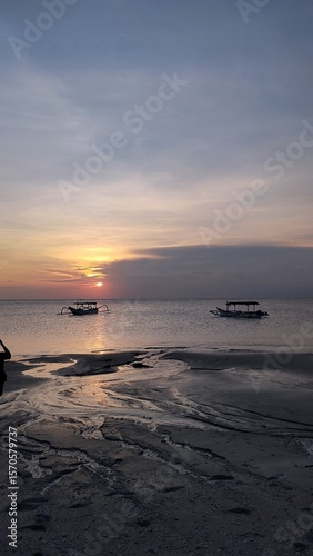 Golden Sunset Over Calm Ocean with Traditional Fishing Boats