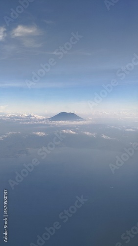 Majestic Mountain Peak Emerging Above Clouds from Aerial View
