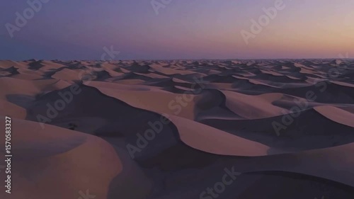 Desert landscape with sand dunes creating soft shadows in evening light