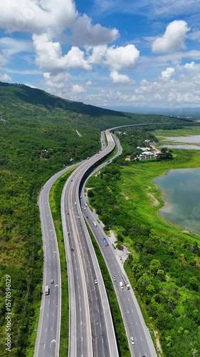 Vertical video drone footage the M6 motorway Nakhon Ratchasima Province - Bang Pa-in Lam Ta Khong River and Mountain Drone shot of scenic landscape rural place traffic. Motorway Korat Thailand 