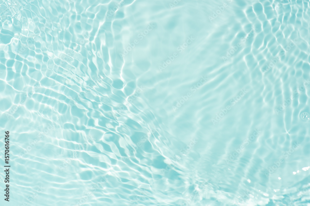Obraz premium Blue water with ripples on the surface. Defocus blurred transparent blue colored clear calm water surface texture with splashes and bubbles. Water waves with shining pattern texture background.