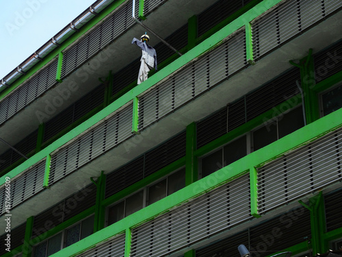 Uniform on a Bright Green Building Ledge in Bangkok