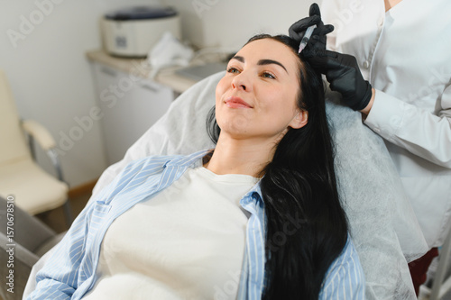 Beautiful middle woman receiving hair mesotherapy injection from competent beautician