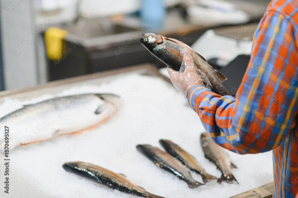 Fototapeta premium Man choosing fresh chilled fish in grocery store
