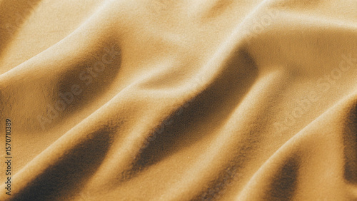 Golden, soft silk satin fabric with a smooth, shiny texture creates a luxurious and elegant golden textile background pattern