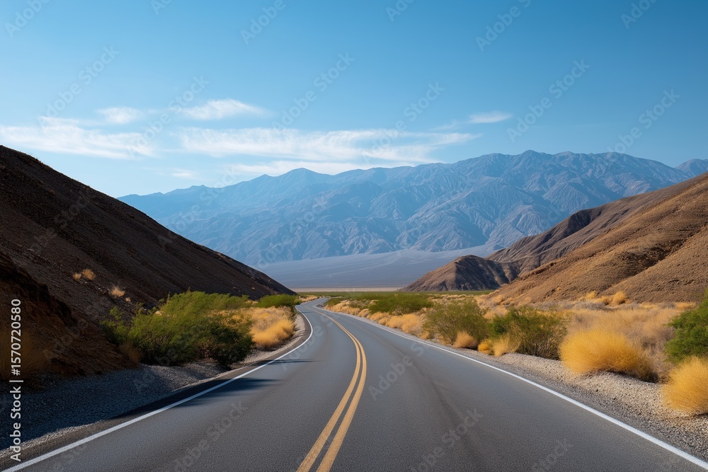 Fototapeta premium Scenic desert road with mountain views under clear blue sky