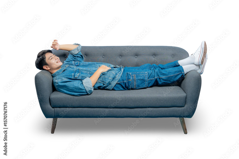 Obraz premium A happy young man gestures upwards while lounging on a sofa, looking relaxed and carefree.