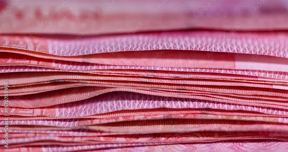 One hundred yuan Chinese money stacked on top of each other, large denomination Red Chinese money stacked together on top