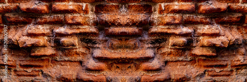 A close-up of a beat-up red brick wall with rough, uneven bricks in shades of red, orange, and brown, showing off years of wear and tear.