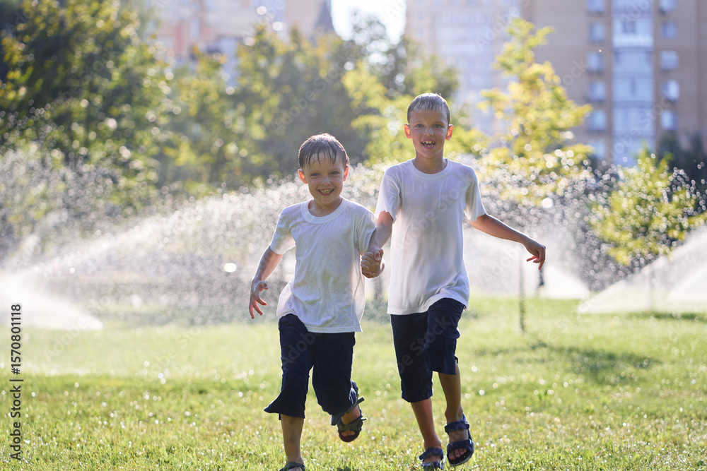 Obraz premium Two Boys Enjoying a Fun Day Playing in Outdoor Sprinklers