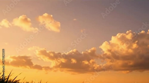 Tranquil Mountaintop at Golden Hour with Drifting Clouds and Gentle Wind Through Grass