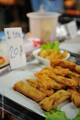 Por Pia Tod (Thai Fried Spring Rolls) for sale at food stall in night market in Thailand.