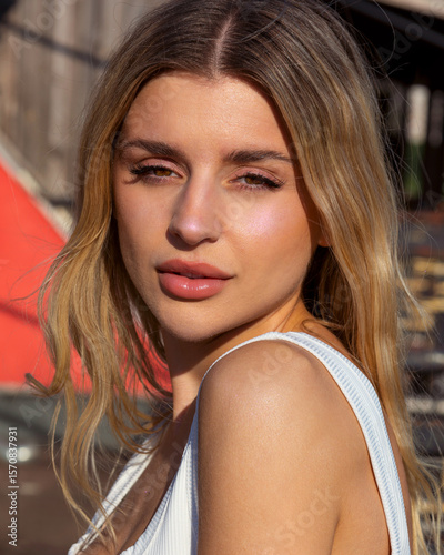 Close-up portrait of a beautiful woman with sun-kissed makeup in golden tones, glowing skin, and soft summer vibes. Warm sunlight highlights her natural beauty, perfect for beauty, fashion, and lifest