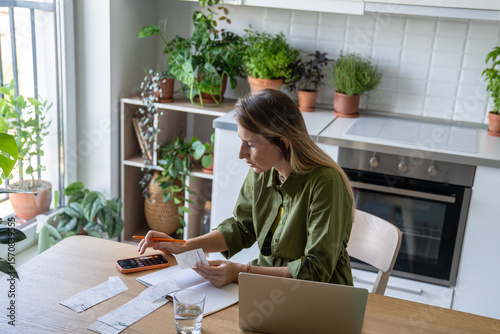 Exhausted pensive woman calculating utility bills on smartphone calculator. Financial pressure, cost saving, inflation household expenses, money worries, budget plan, personal finance management
