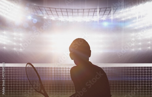 Silhouette tennis player in illuminated stadium