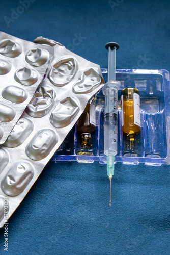 medical tablets with syringe and empty drug bottle indoors