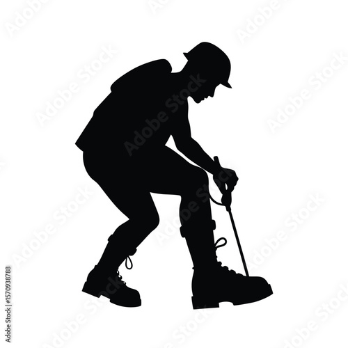 Black silhouette of mountaineer adjusting ice boot strap