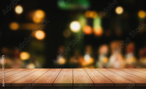 Empty wooden table top with lights bokeh on blur restaurant background.