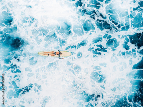 Photography Woman on surfboard in blue ocean with foam waves