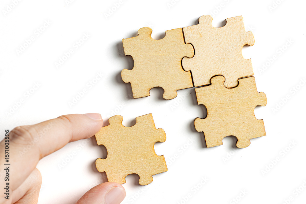 hand holding wooden jigsaw puzzle pieces. To complete the puzzle. business and teamwork concept. hand holding wooden jigsaw puzzle pieces. To complete the puzzle. business and teamwork concept.