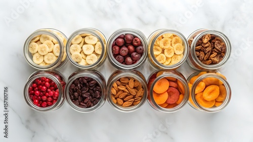 Assortment of Dried Fruits and Nuts in Glass Jars on Marble Background