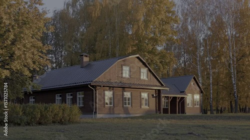 Charming wooden cabin nestled among golden autumn trees at sunset — perfect for seasonal, rural living, or real estate visuals.
