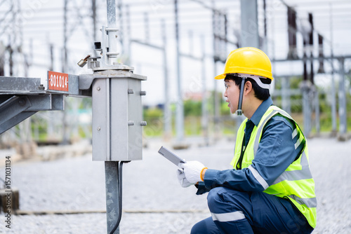 Engineer is working at high voltage substation performing inspection and check of power infrastructure to ensure safety and reliability in electrical system