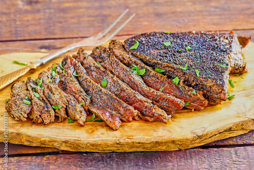 coffee rubbed flank steak, pan roasted and cooked rare, topped with fresh parsley, with a serving fork