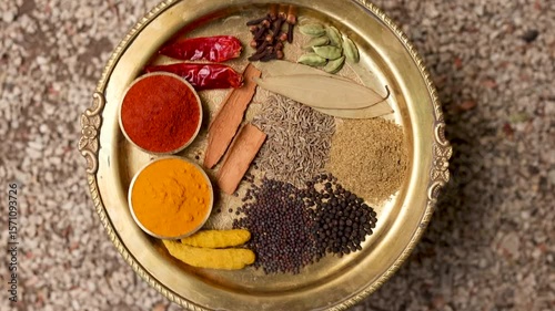 Indian spices on one brass plate isolated 