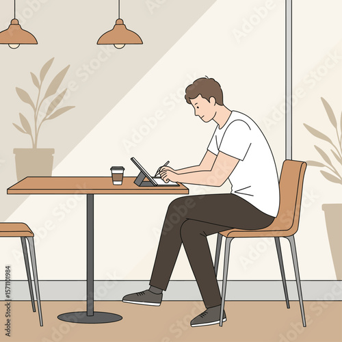 A young man sits in a cafe, working on a digital tablet with a stylus.