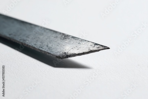 Sharp metal blade casting shadows, showcasing texture and precis